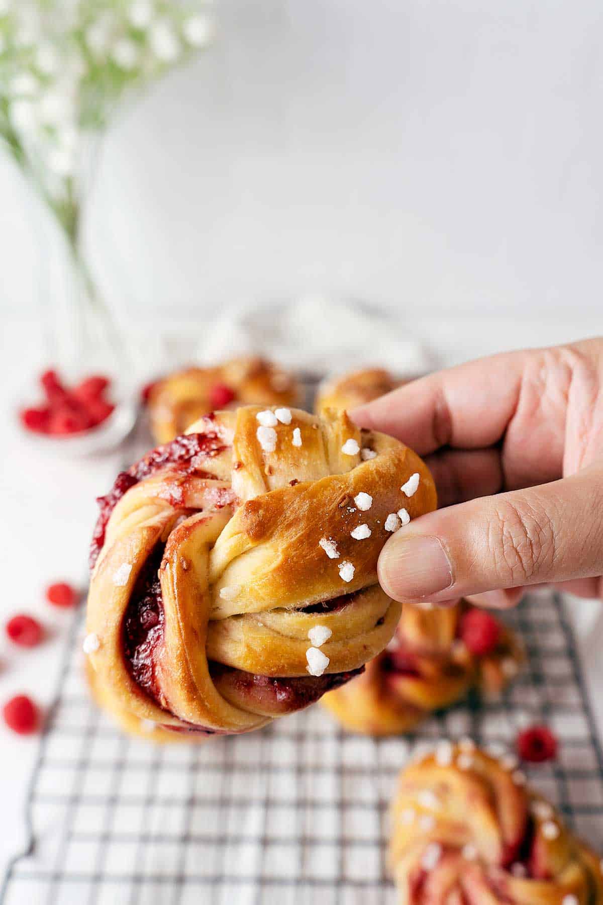 holding a raspberry twisted bun