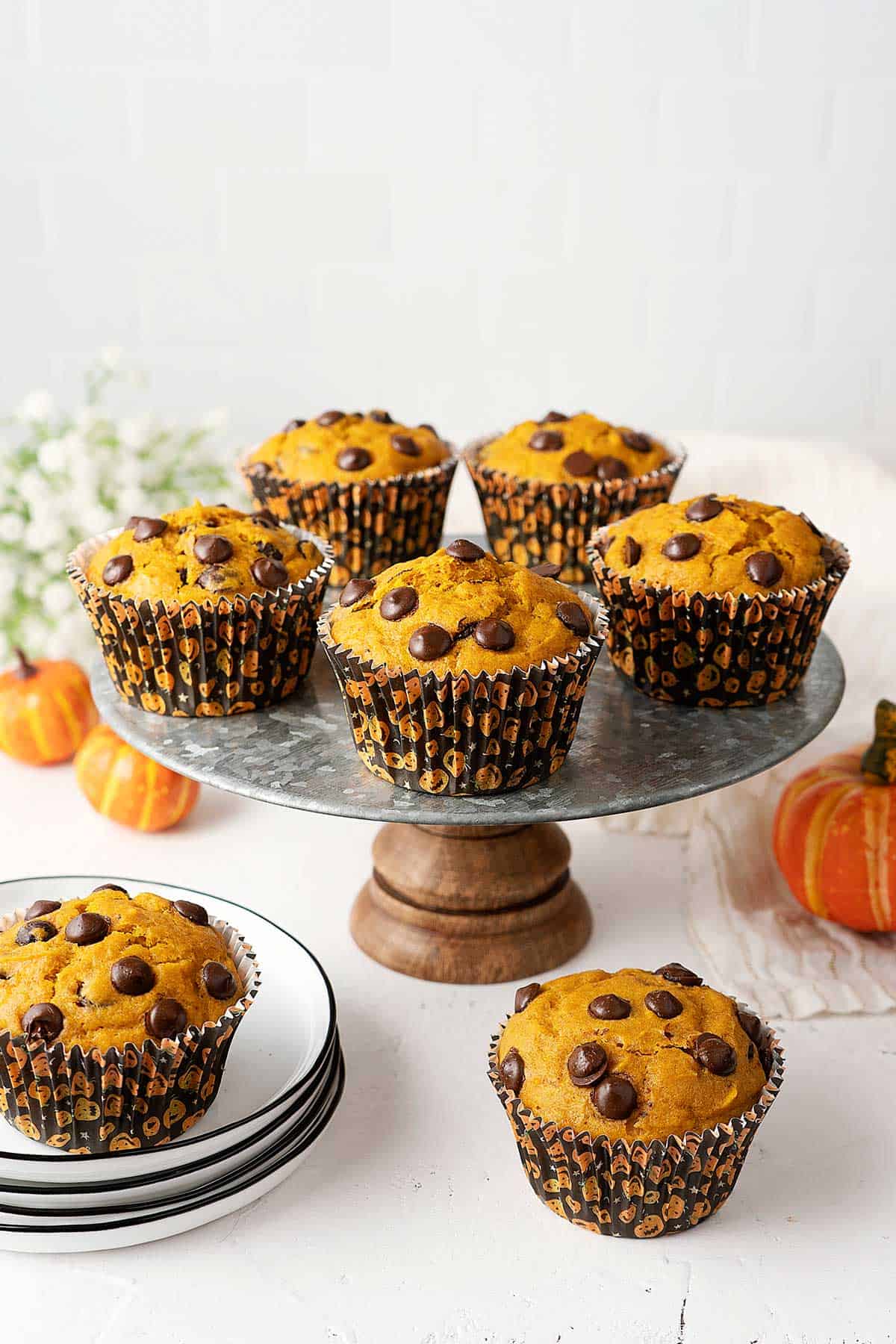 pumpkin chocolate chip muffins on a cake stand.