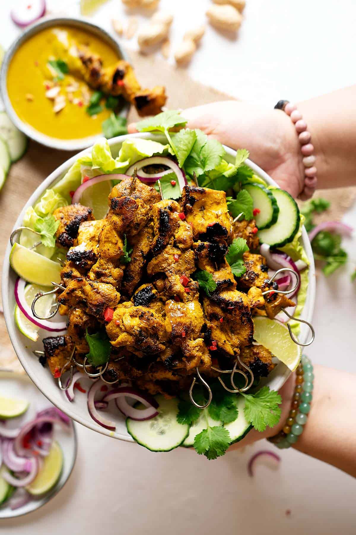 Holding a plate of easy chicken satay