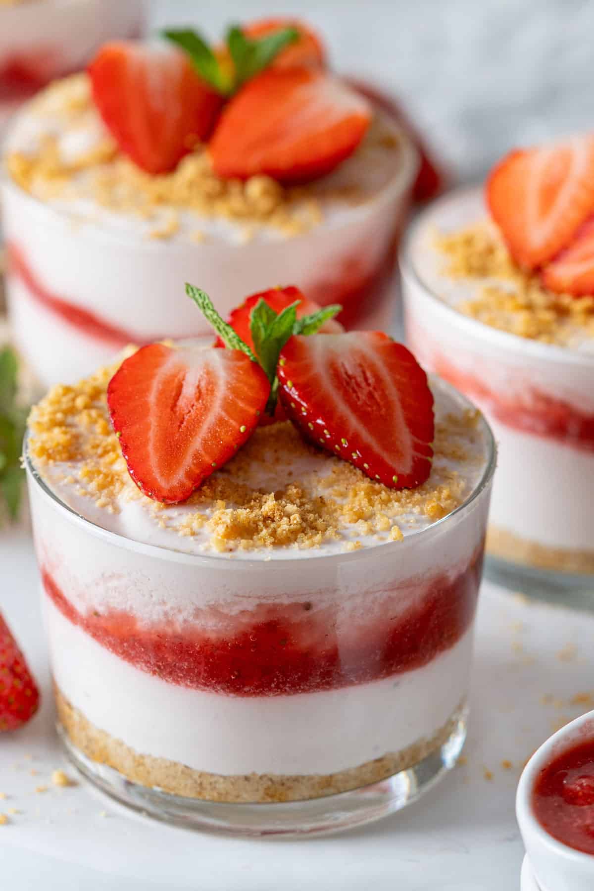 tres vasitos con postre de fresa.